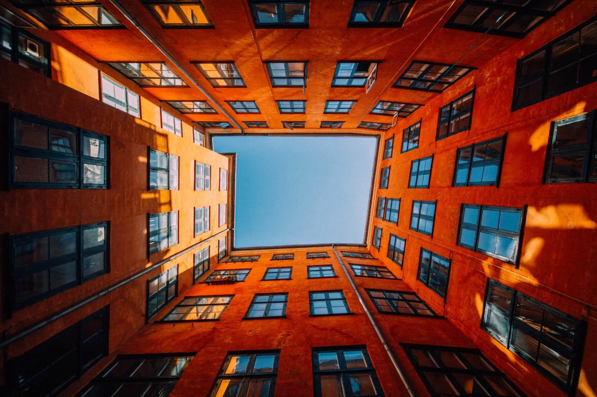 low angle shot of a unique high rise orange building touching the sky
